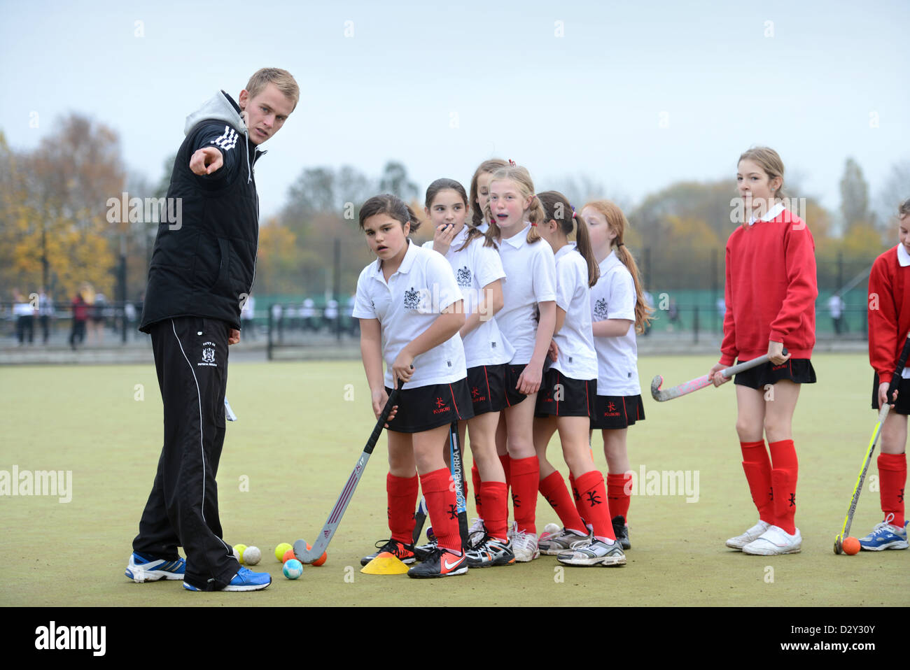 Un insegnante di giochi incarica le ragazze durante la pratica di hockey a Pâté Grammar School di Cheltenham, Gloucestershire REGNO UNITO Foto Stock