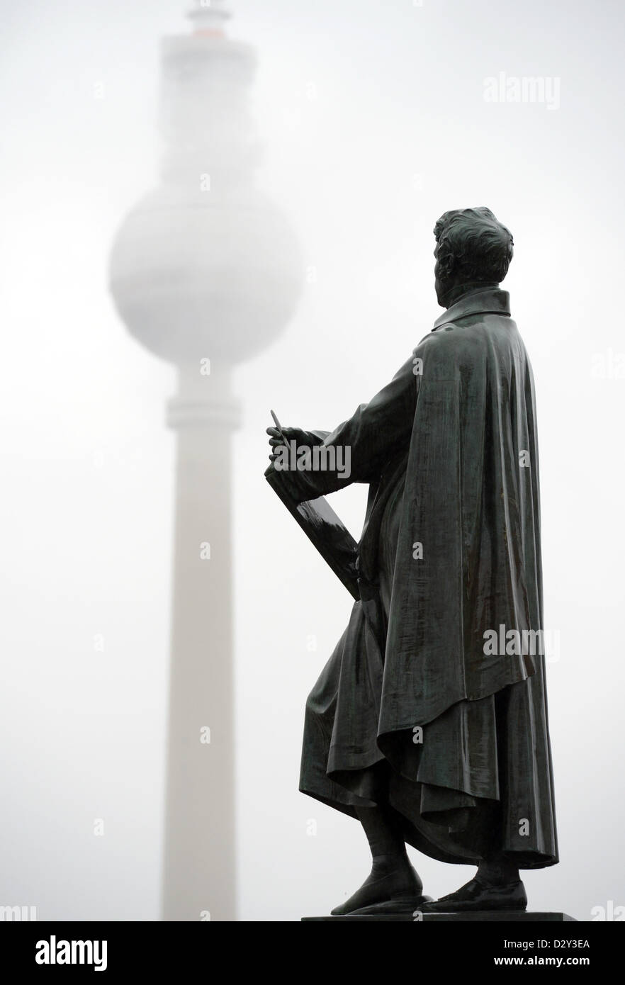 La torre della televisione è raffigurato dietro le nuvole e una scultura di architetto prussiano Karl Friedrich Schinkel a Berlino, Germania, 04 febbraio 2013. Foto: RAINER JENSEN Foto Stock