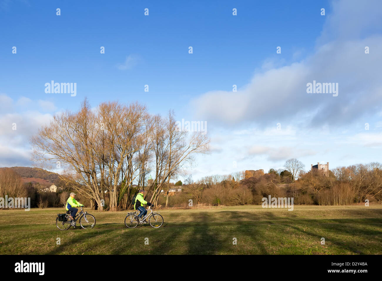 Due persone ciclismo su pista ciclabile attraverso Prati di Castello, Abergavenny, Wales, Regno Unito Foto Stock