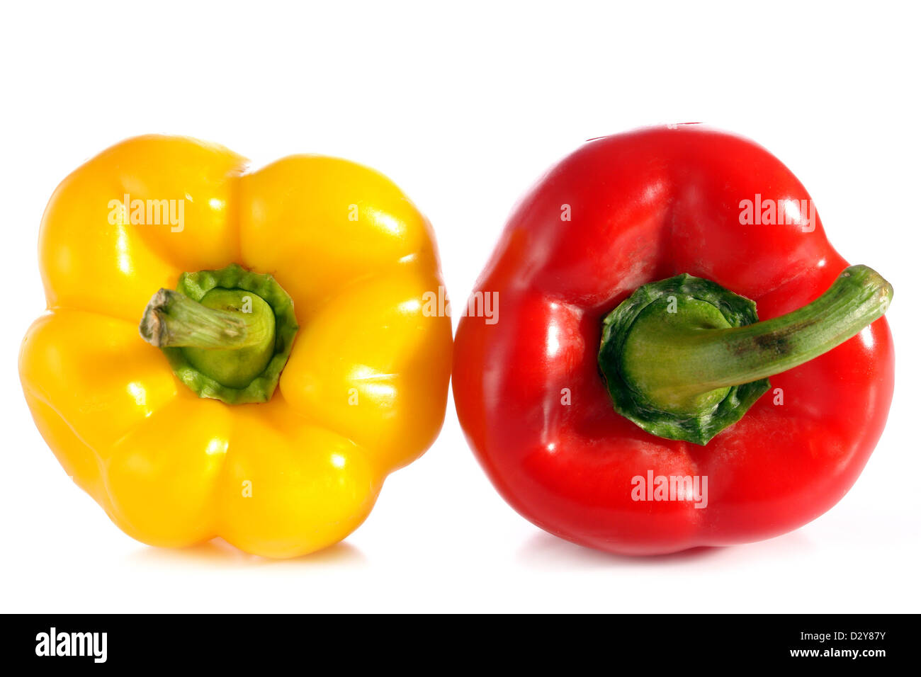 Due peperoni in giallo e rosso su bianco Foto Stock