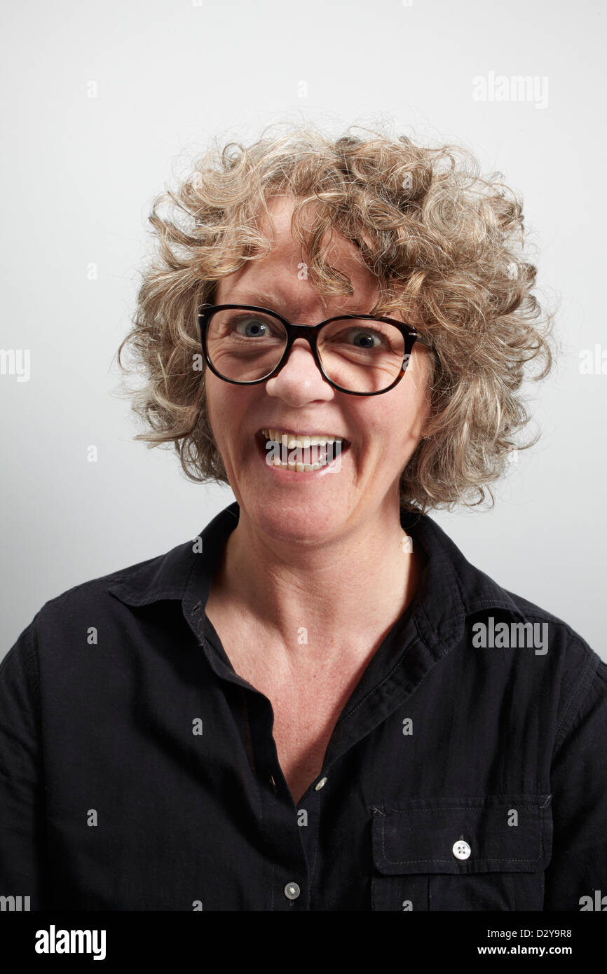 Donna con capelli ricci che indossa occhiali grandi e che sembra un po' pazza Foto Stock