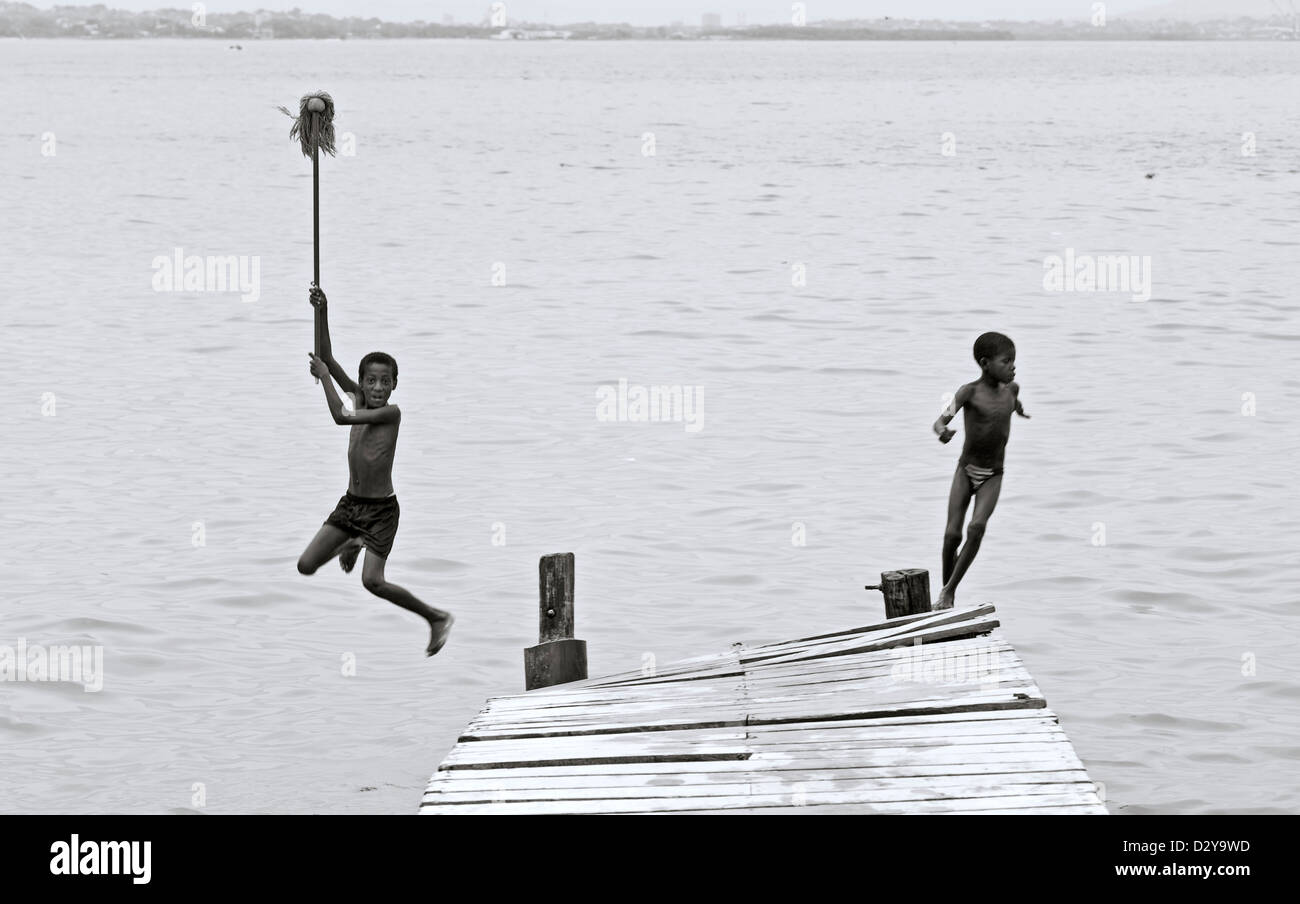 La Colombia, Tierrabomba, vista di giovani ragazzi di saltare fuori jetty in acqua Foto Stock