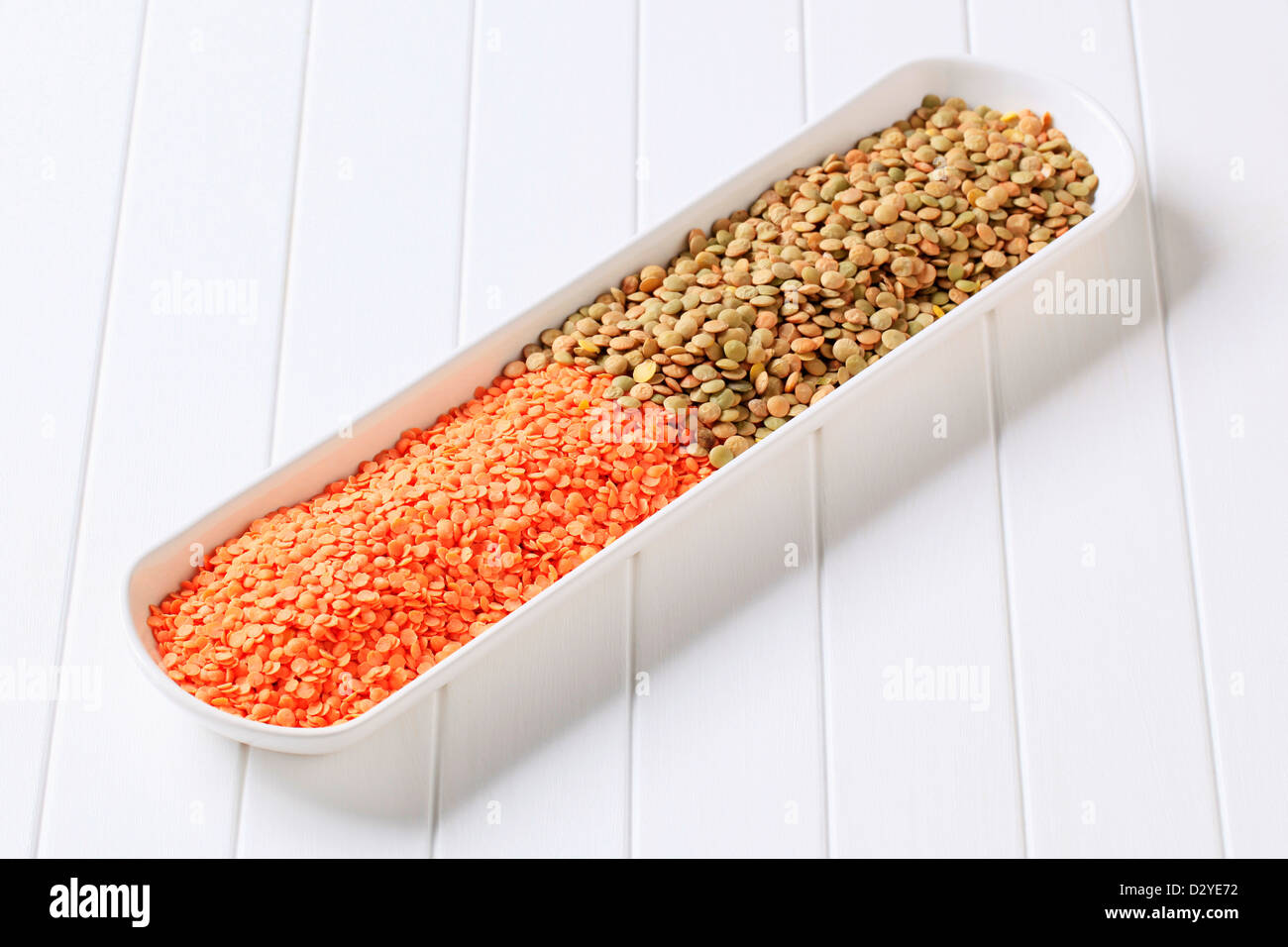 Materie in rosso e marrone e le lenticchie in un piatto lungo Foto Stock