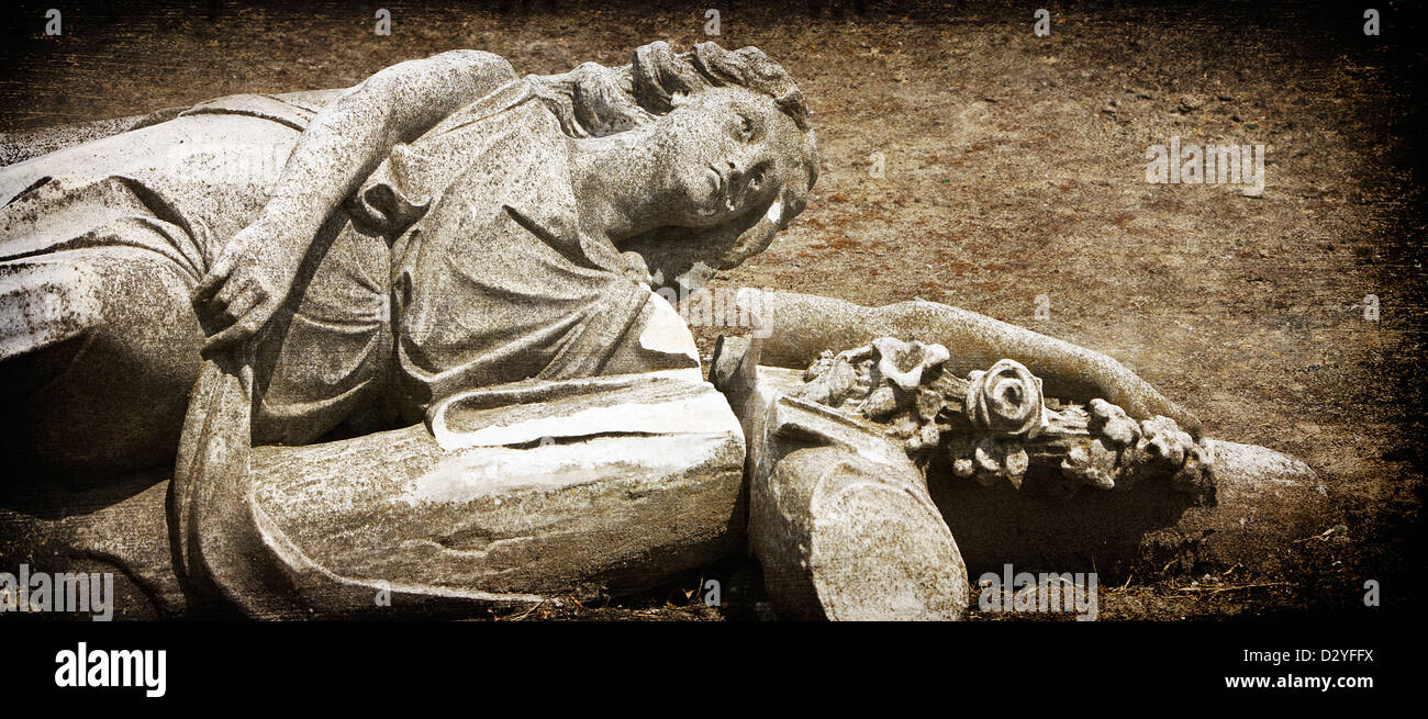 Un angelo caduto. Statua di pietra recante rotta sul terreno di un cimitero a seguito di terremoti in Christchurch, Nuova Zelanda. Foto Stock
