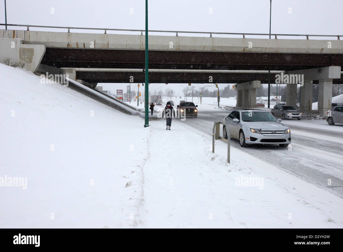 La gente a piedi e in auto percorrendo ottava strada sotto unità cerchio sottopassaggio Saskatoon Saskatchewan Canada Foto Stock