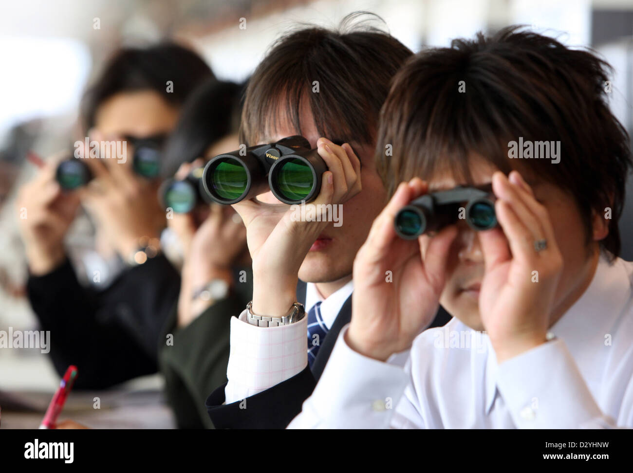 Tokyo, Giappone, gli uomini alla ricerca attraverso il binocolo Foto Stock