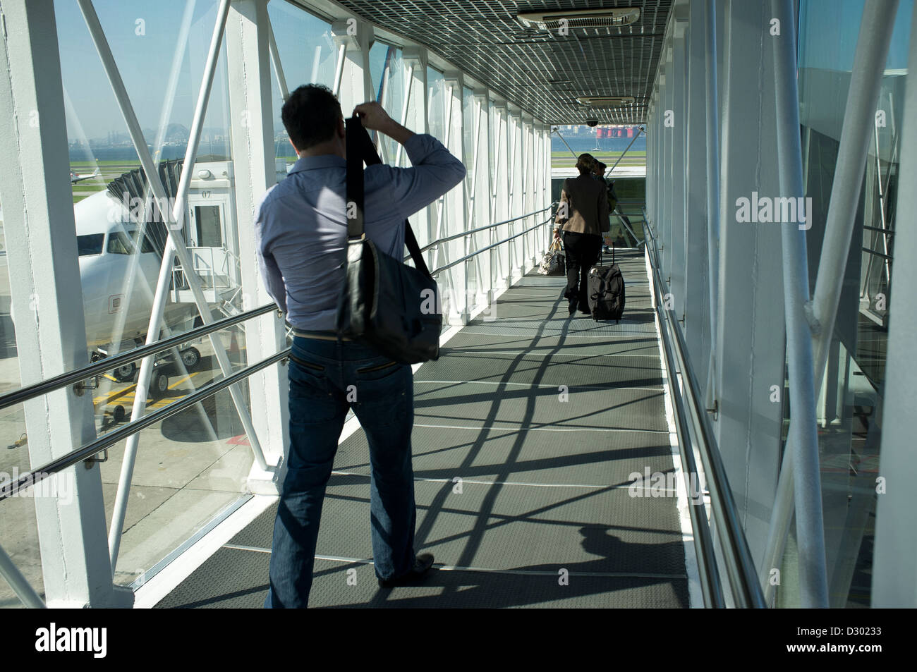 Passeggeri a piedi attraverso un getto ponte sul loro modo al velivolo all'Aeroporto Santos Dumont nel centro di Rio de Janeiro, Brasile Foto Stock