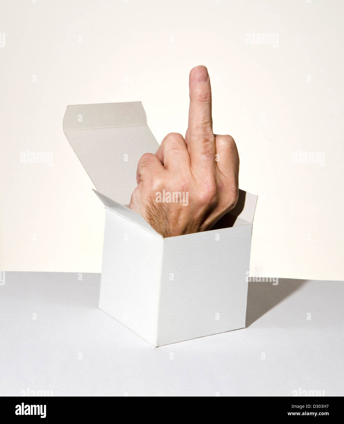 Mano che saltano fuori dalla scatola con Fuck you segno Foto Stock