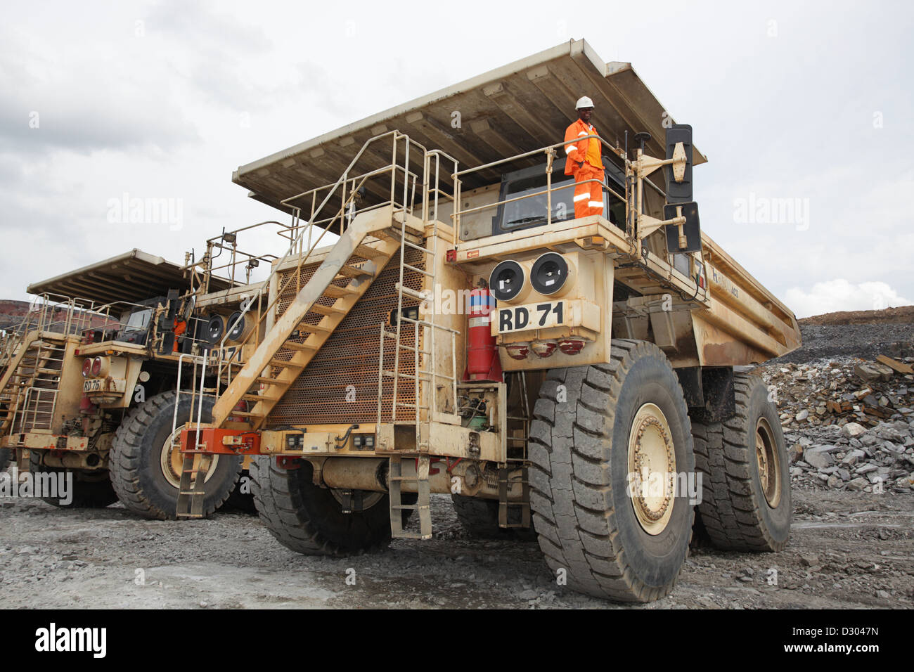 Conducente in piedi sulla parte superiore della sua miniera di Hitachi carrello Foto Stock