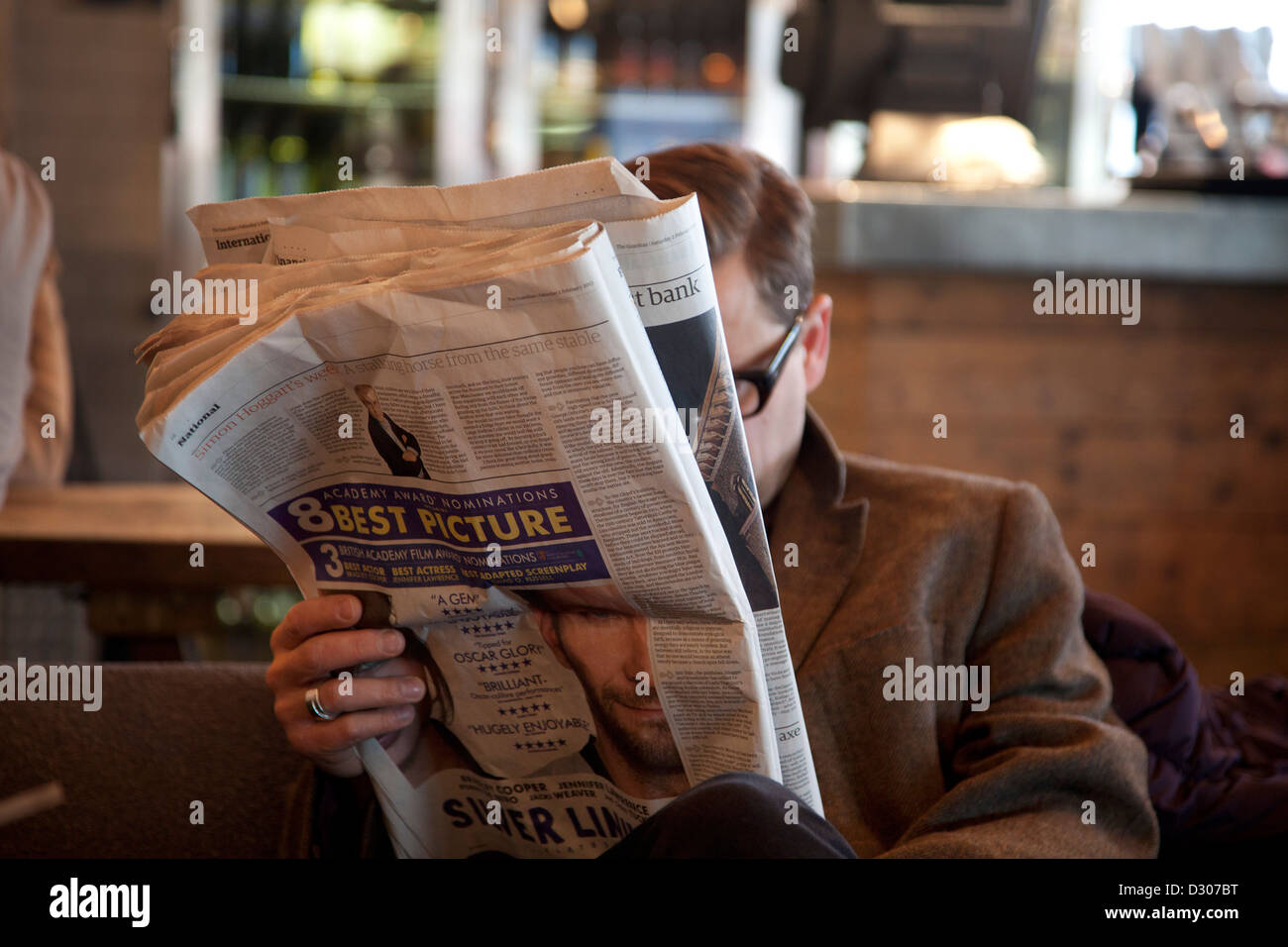 Un uomo leggendo il quotidiano The Guardian. Foto Stock