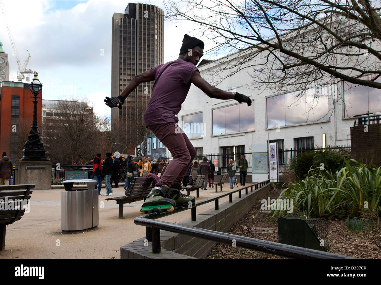Southbank di Londra. Aggressive skater inline esegue un glide trucco. Foto Stock