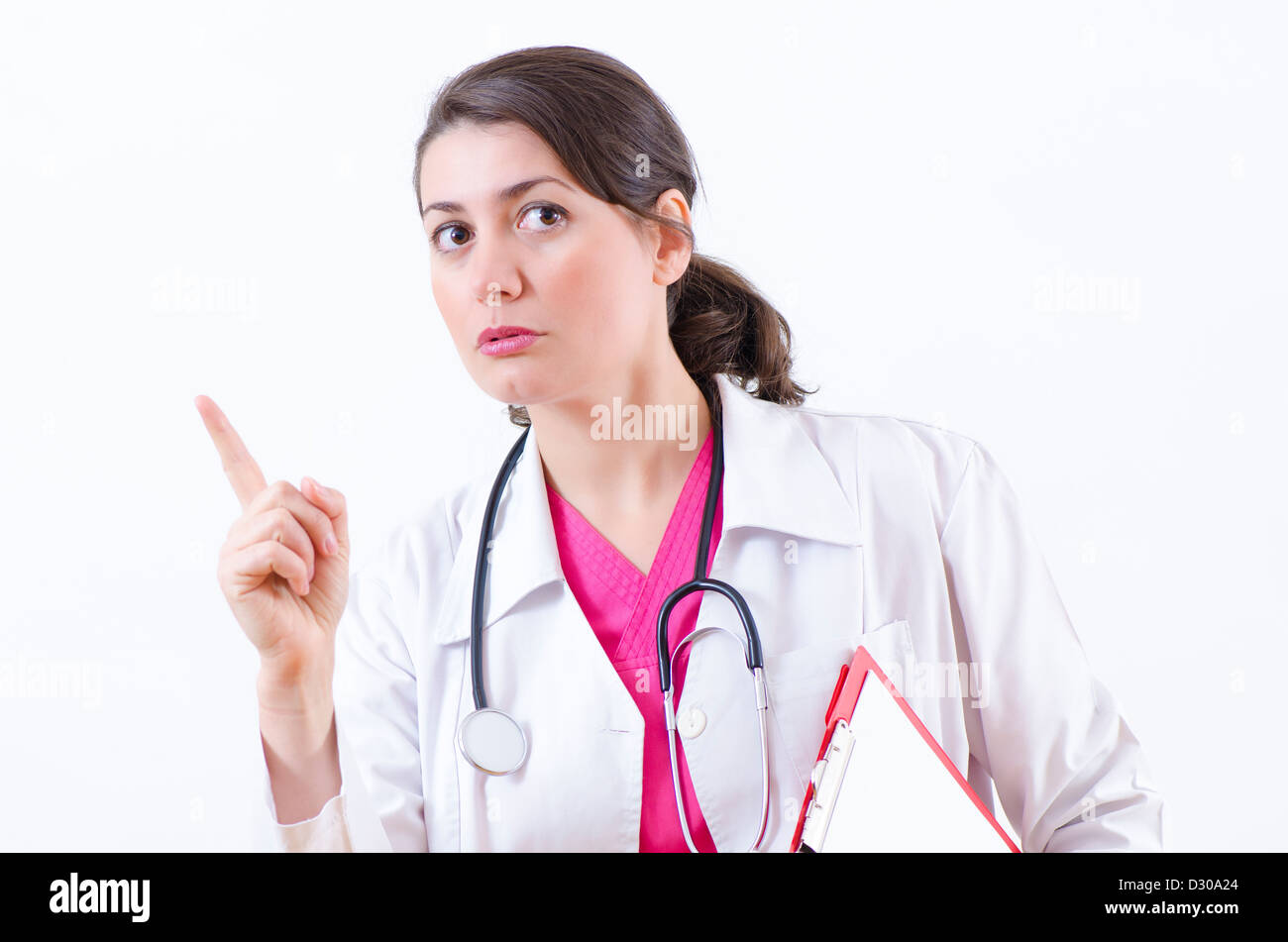 Un giovane medico donna gesticolando con benevolenza Foto Stock