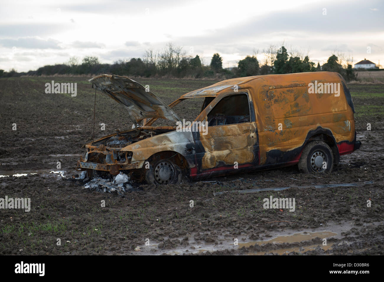 Immagine di bruciato Ford Escort van in un campo fangoso su terreni agricoli a Battlesbridge, Essex, Regno Unito. Foto Stock
