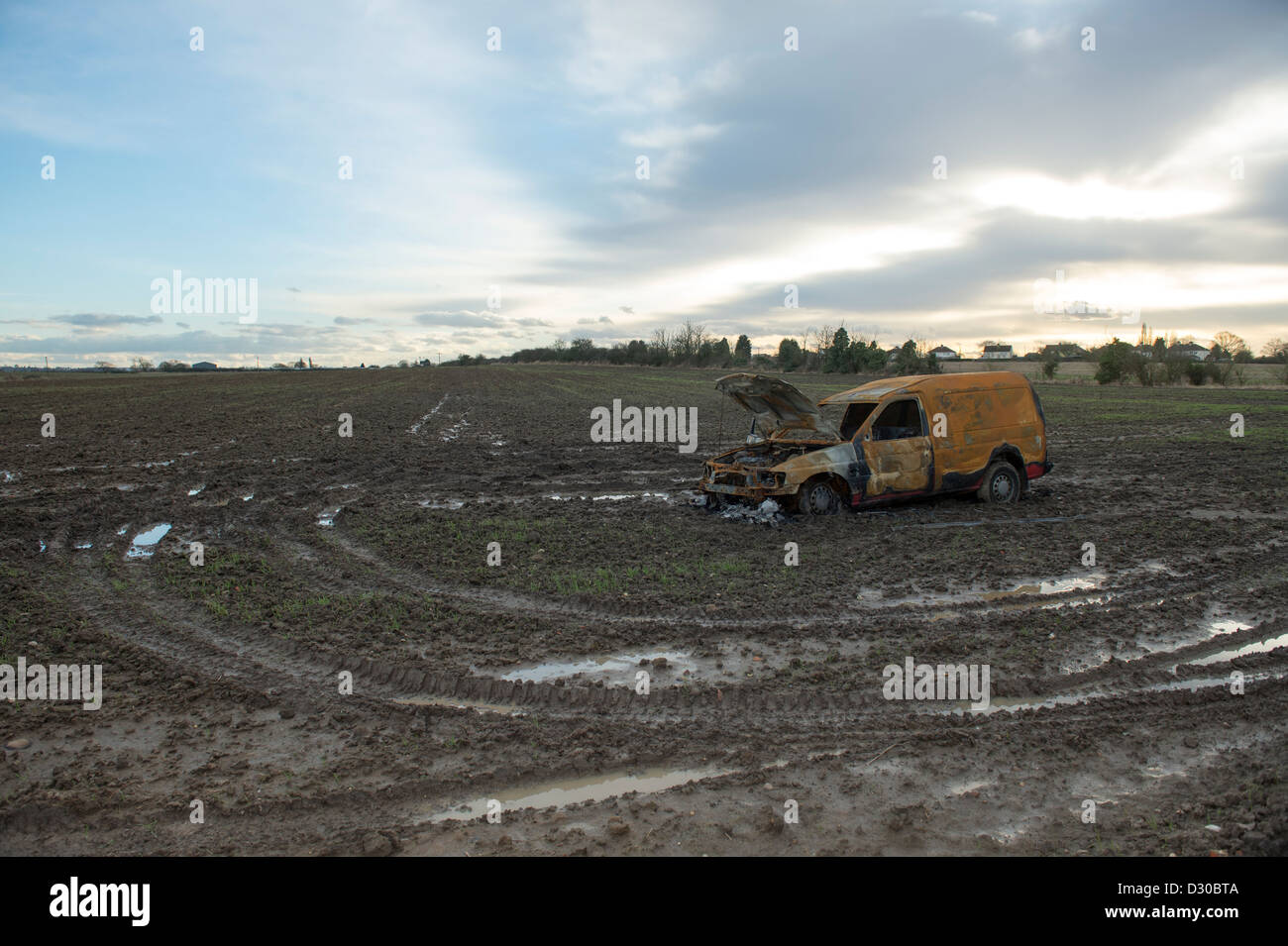 Immagine di bruciato Ford Escort van in un campo fangoso su terreni agricoli a Battlesbridge, Essex, Regno Unito. Foto Stock