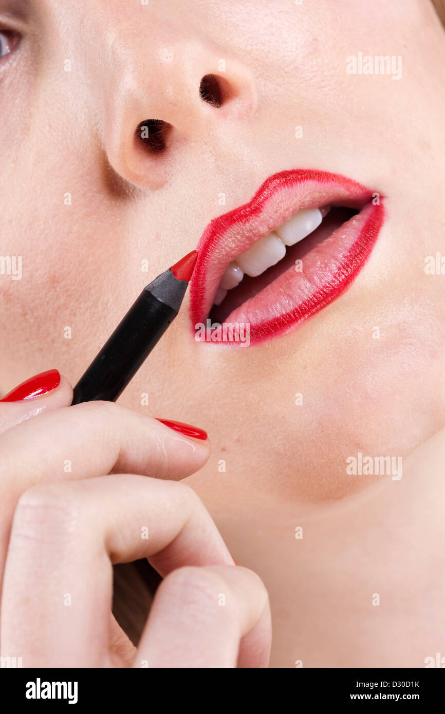 Donna di applicare colore rosso brillante lip-liner Foto Stock