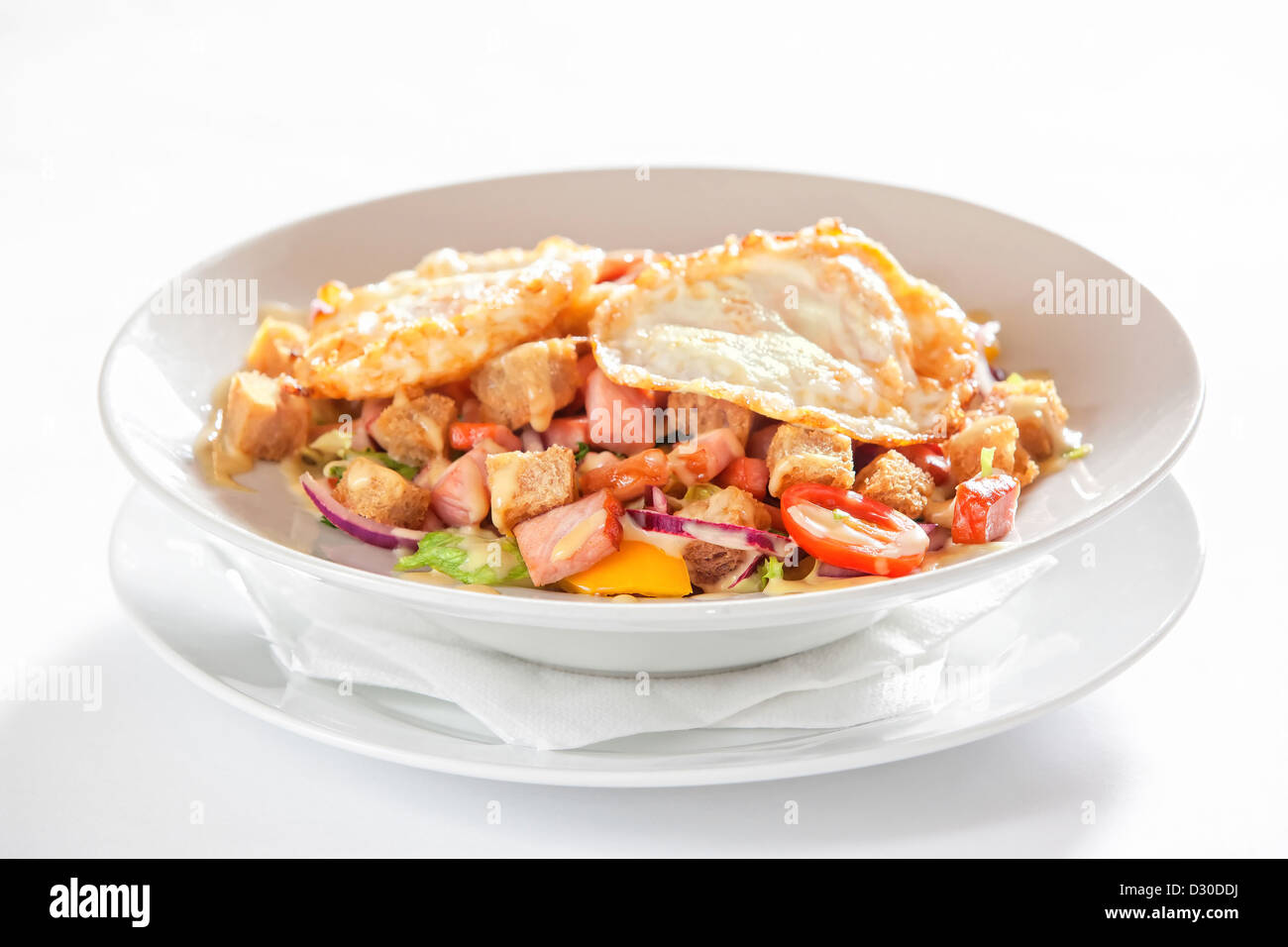 Insalata di verdure, pancetta e uova fritte su sfondo bianco Foto Stock