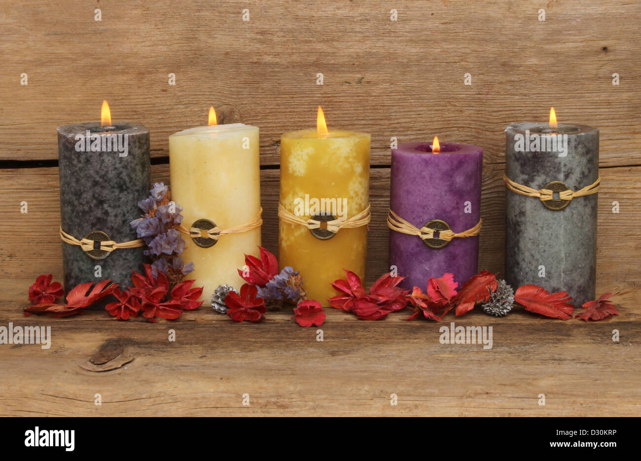 Cinque masterizzazione di Feng Shui candele e pot-pourri su uno sfondo di vecchio legno stagionato Foto Stock