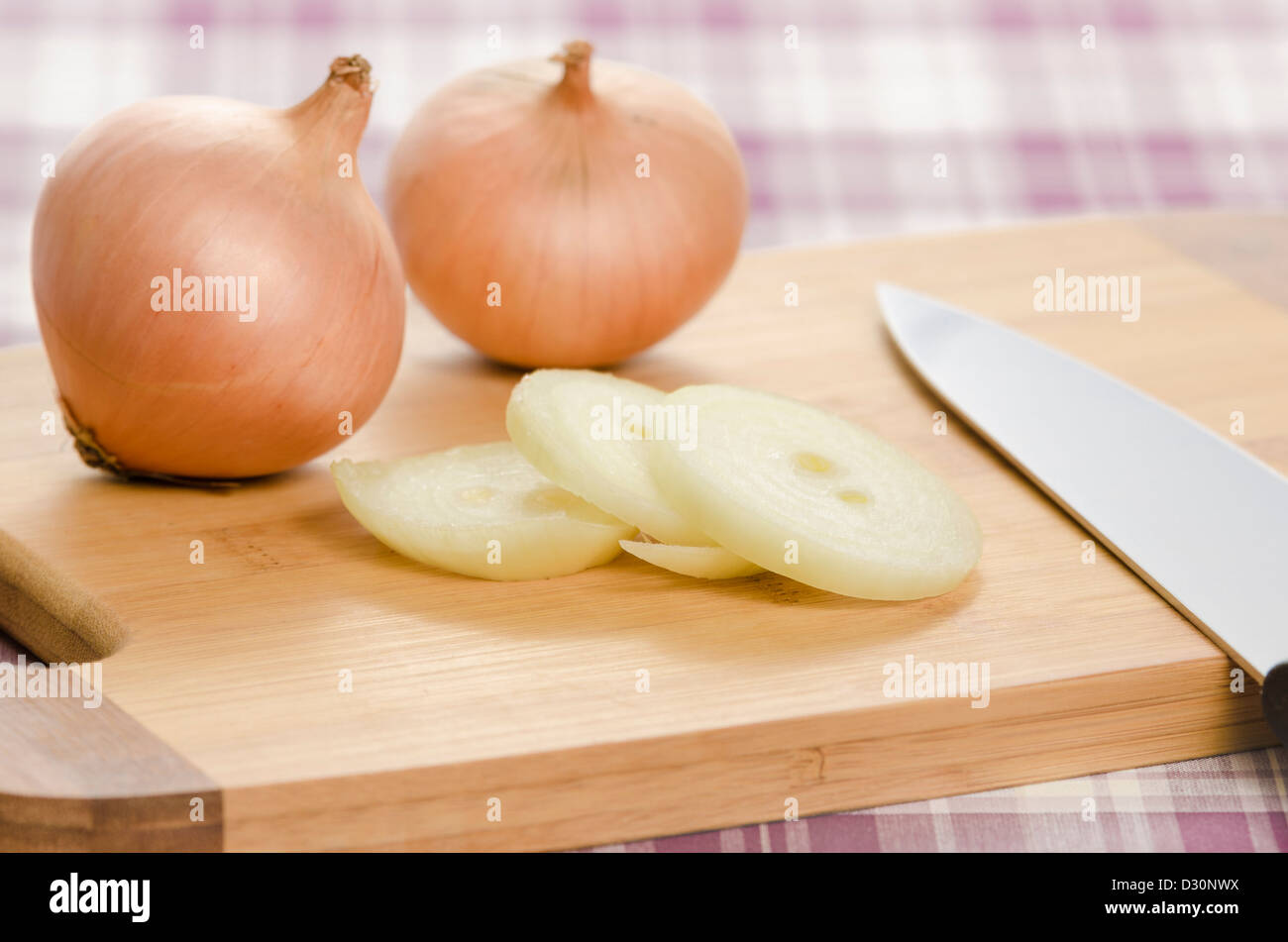 Cipolle e fette di cipolla sul tagliere. Alimenti sani ingredienti essendo elaborati mentre si effettua il cibo. Foto Stock