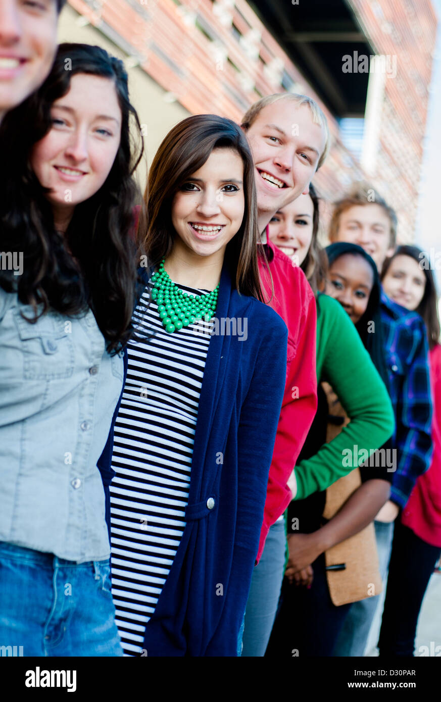 Gruppo di diversi studenti al di fuori sorridente in una linea Foto Stock