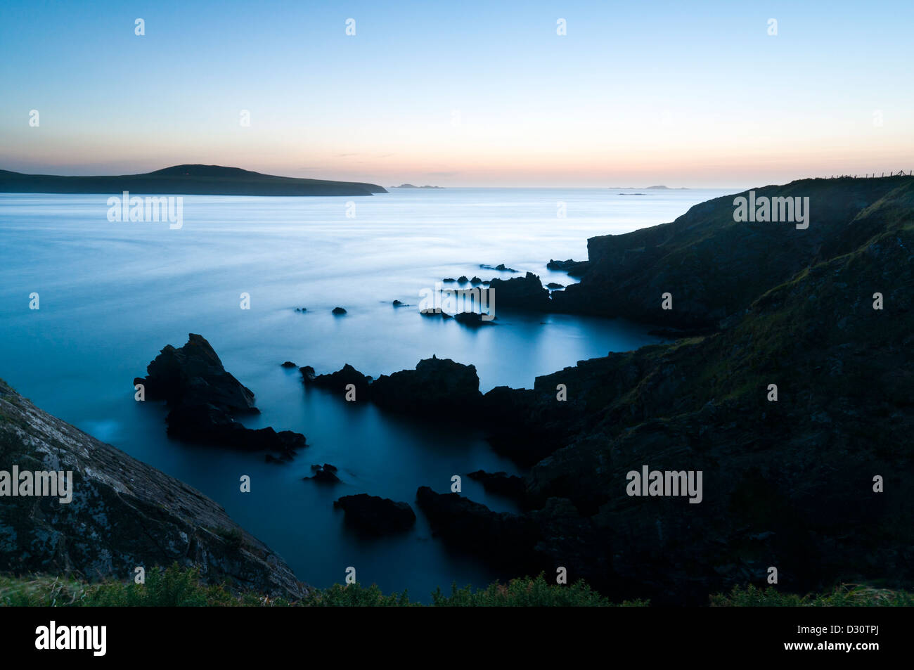 Ramsey suono e isola nella distanza poco dopo il tramonto con il flusso della marea che mostra fino a causa di una lunga esposizione. Foto Stock