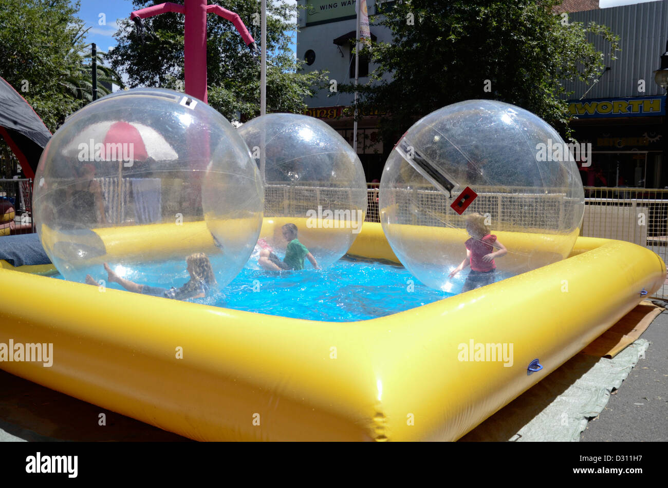I bambini a giocare in grandi bolle di plastica sull'acqua. Tamworth street festival Foto Stock