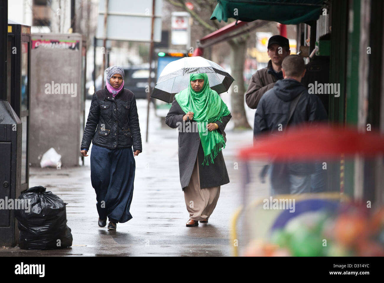 Donna musulmana passeggiando lungo le strade di Acton Town, West London Foto Stock