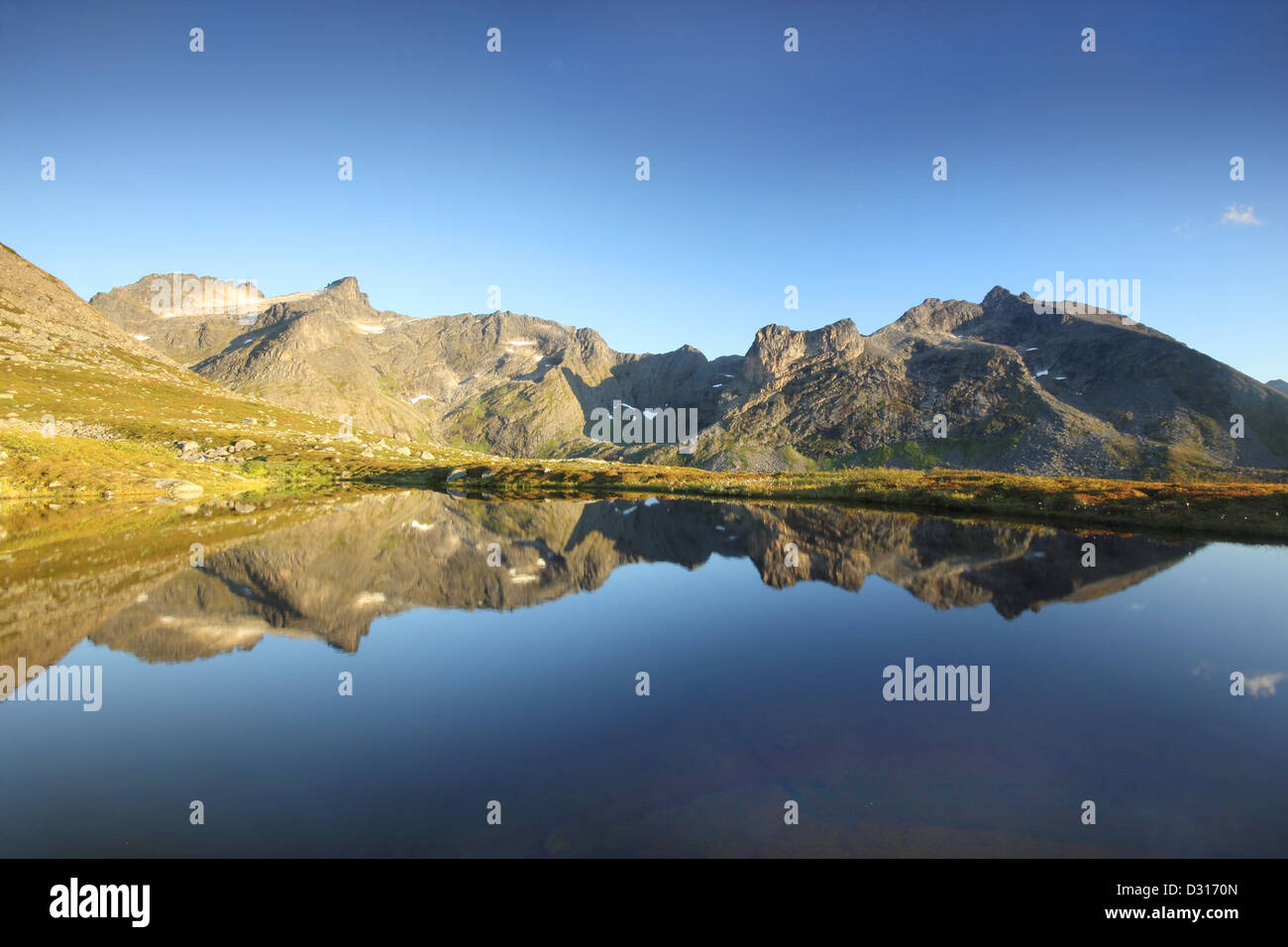 Picchi di montagna riflessa in un lago glaciale nel nord della Norvegia Foto Stock