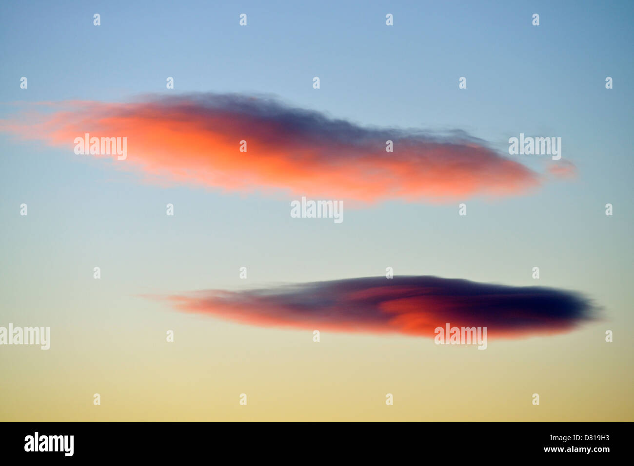 Due rosa rosso nubi lenticolari al tramonto Foto Stock