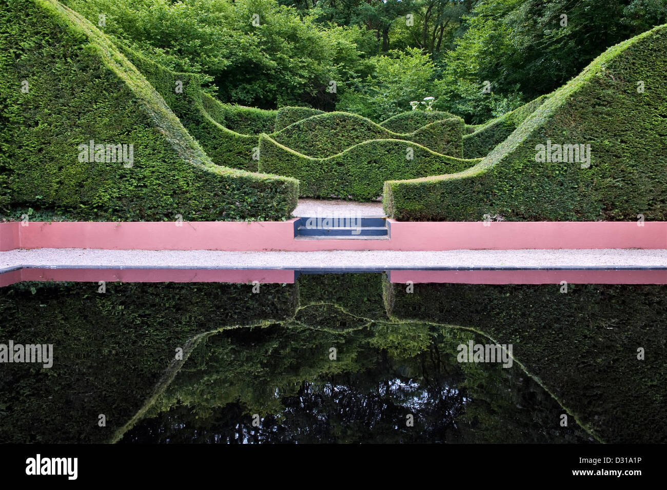 Le siepi accuratamente tagliate si riflettono nella piscina del Veddw House Garden, Devauden, Galles, Regno Unito, un giardino moderno realizzato da Anne Wareham e Charles Hawes Foto Stock