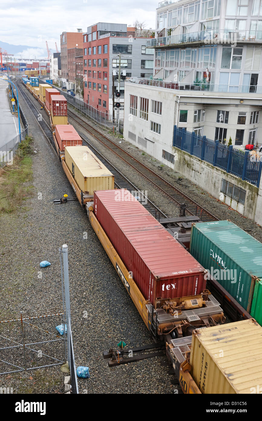 Treno merci merci le vie vicino alla strada principale e la porta dock metro Vancouver BC Canada Foto Stock