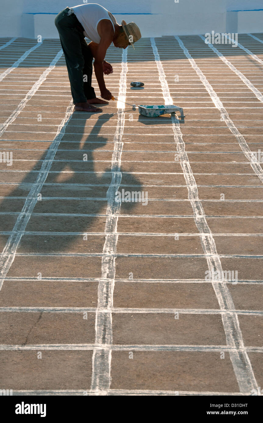 Pittura a mano i quadratini bianchi in una chiesa cortile, Grecia Foto Stock