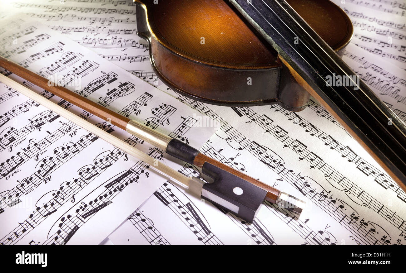 Legno vecchio violino e archetto su punteggi. Foto Stock
