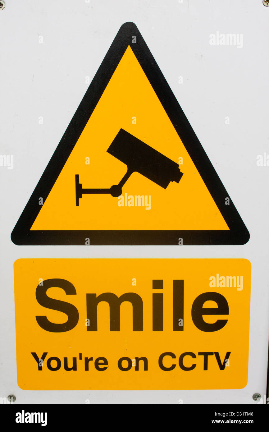 'Smile sei su CCTV' firmare con telecamera di sorveglianza su sfondo giallo nel triangolo nero Denbigh Wales UK Foto Stock