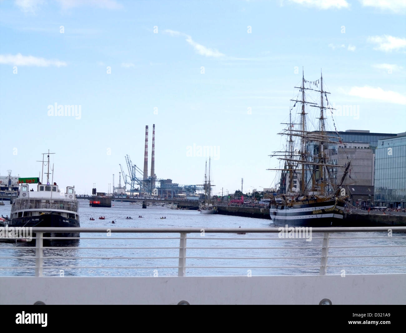 Barche sul fiume Liffey a Dublino Irlanda come si vede dal Samuel Beckett Bridge con le torri gemelle a distanza Foto Stock