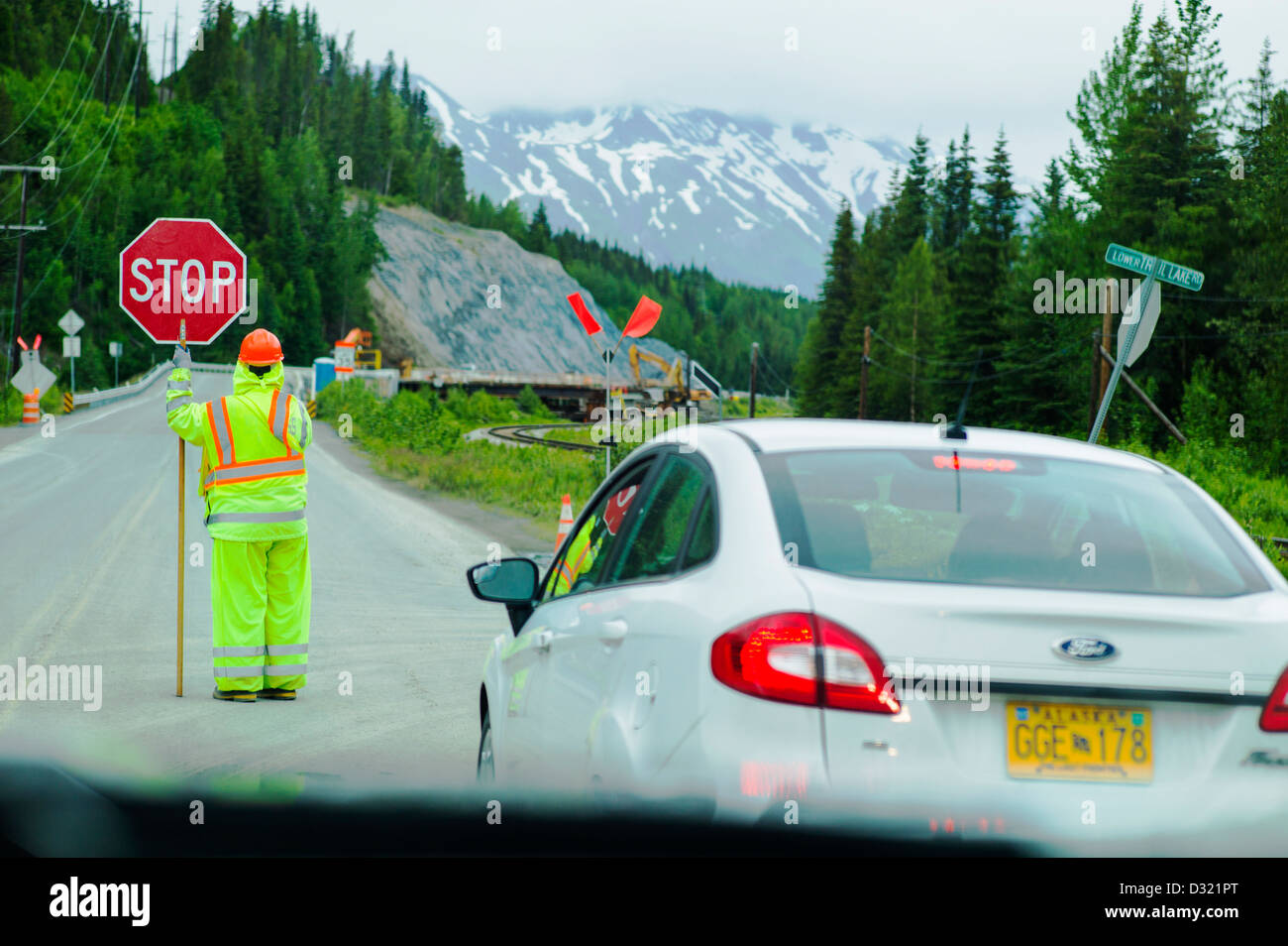Flagger, bandiera o persona, bloccano il traffico per la costruzione su autostrada 1 vicino a Omero, Penisola di Kenai, Alaska, STATI UNITI D'AMERICA Foto Stock
