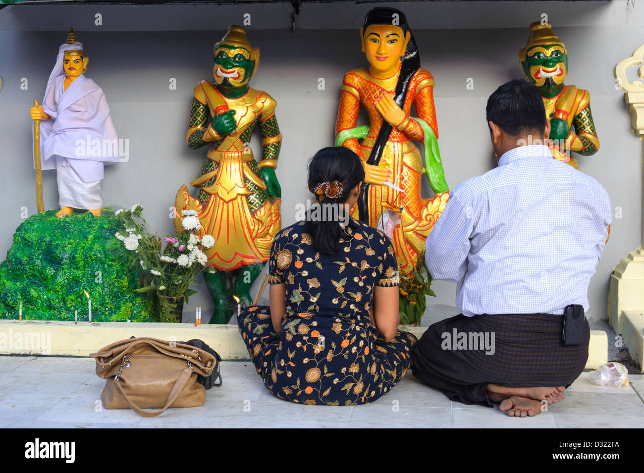 Un paio di pregare prima di Divinità buddiste a Shwedagon pagoda Yangon Foto Stock