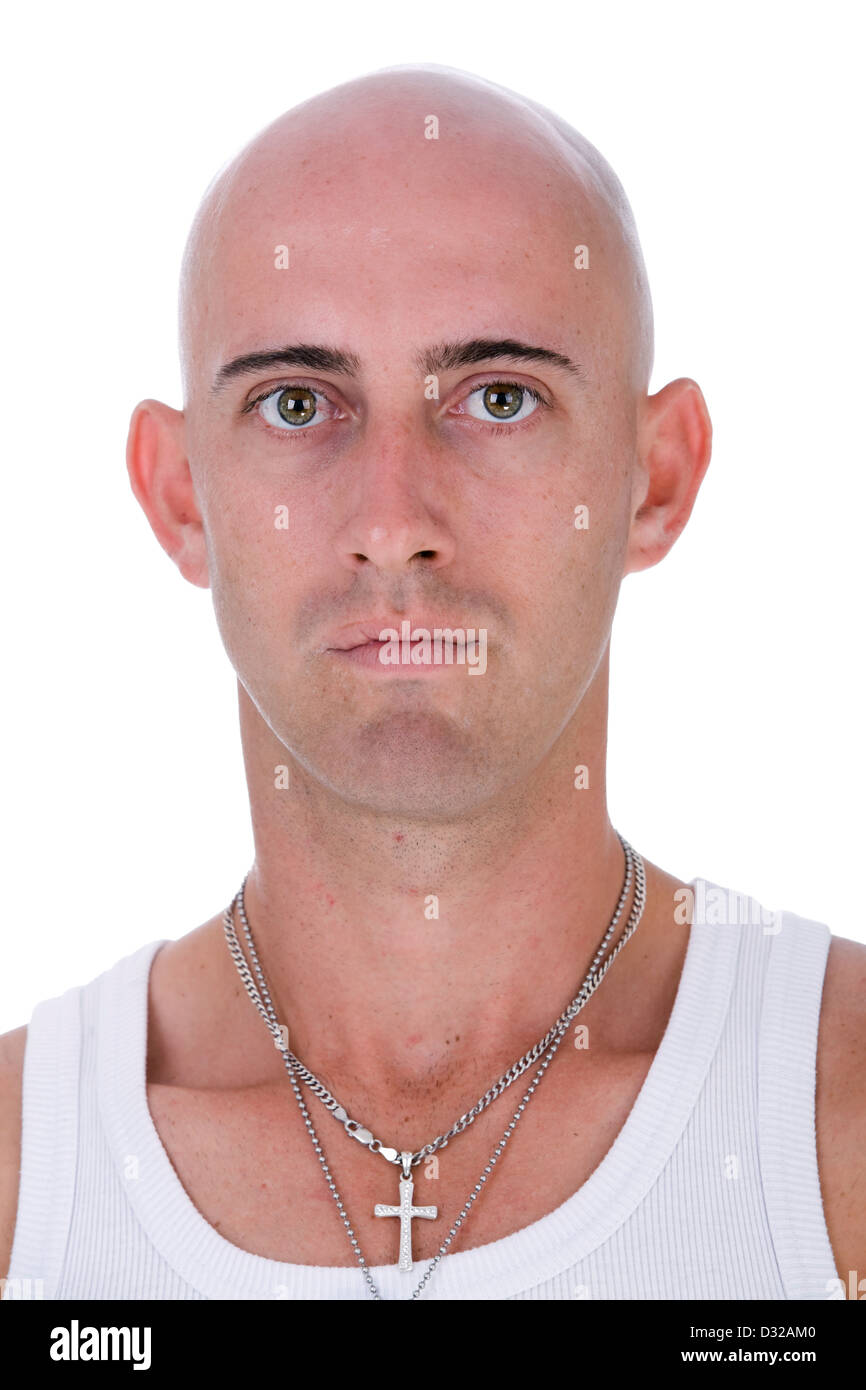 Un ritratto di una giovane calvo uomo caucasico con grandi occhi nocciola indossando un singoletto bianco e argento crocifisso fissando alla fotocamera Foto Stock