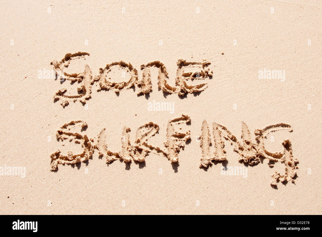 Gone surfing scritto di sabbia su una spiaggia Foto Stock