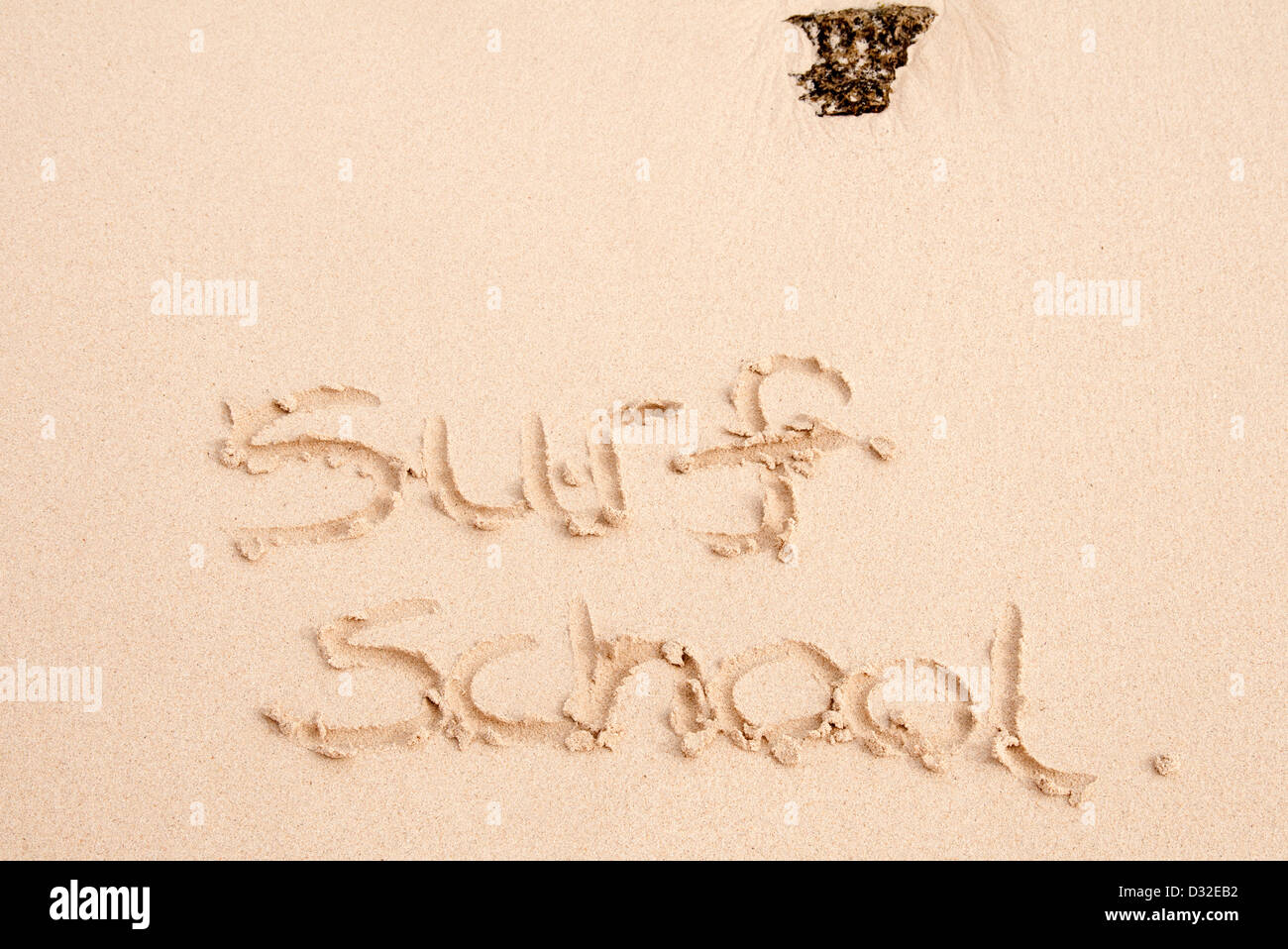 Scuola di surf scritto nella sabbia sulla spiaggia Foto Stock