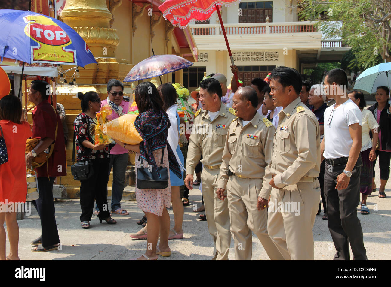 Sorridente officer presso la cerimonia di iniziazione di un monaco novizio a un tempio in Pranburi, Tailandia in una giornata calda. Foto Stock