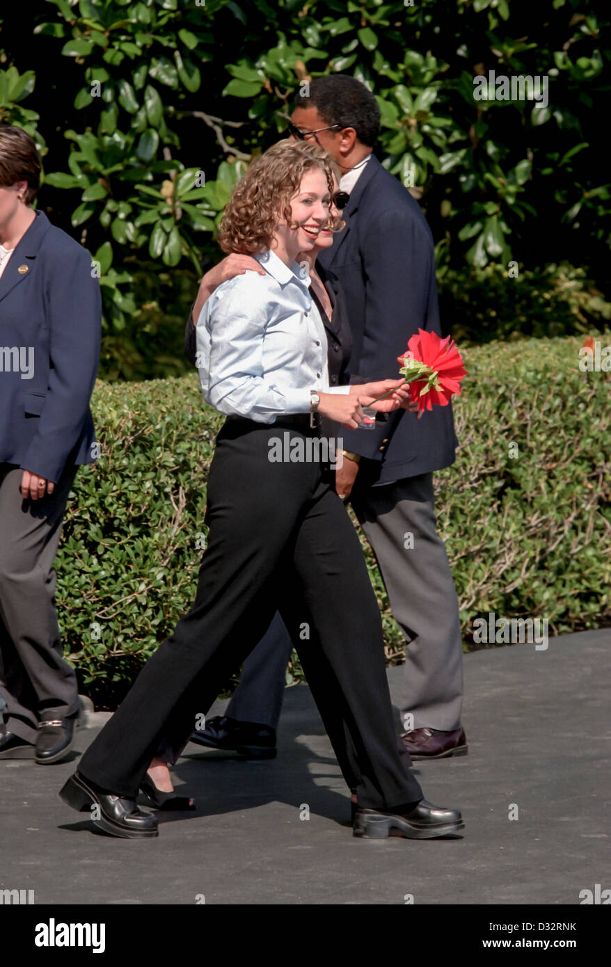 Chelsea Clinton tenendo un fiore di seta cammina con sua madre prima signora Hillary Rodham Clinton a bordo Marine un elicottero sul prato Sud della Casa Bianca Agosto 19, 1999 a Washington, DC. Il Clinton sono in viaggio per il Vigneto di Martha per una vacanza. Foto Stock