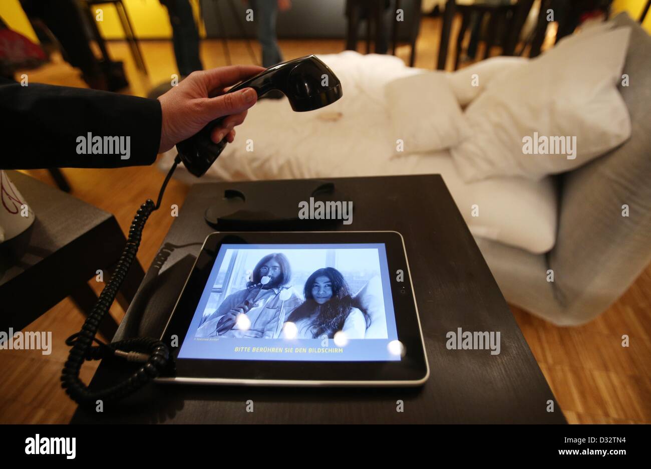Lubecca, Germania. 7 febbraio 2013. Una donna guarda foto di John Lennon e Yoko Ono durante "letto nell' su un iPad per la mostra "L'arte di John Lennon' a Guenter Grass Hause in Luebeck, Germania, 07 febbraio 2013. La mostra va dal 08 febbraio fino al 02 giugno 2013. Foto: CHRISTIAN CHARISIUS/dpa/Alamy Live News Foto Stock