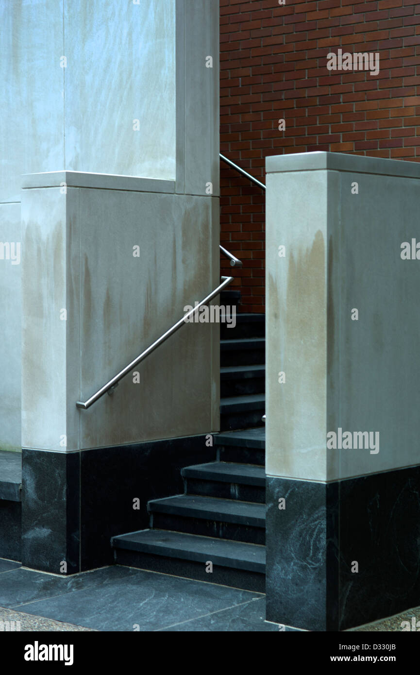 Le scale conducono ad un edificio industriale con un muro di mattoni. Foto Stock