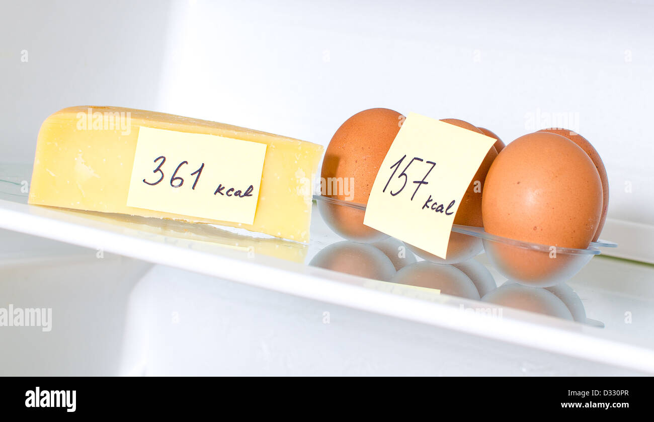 Uova e formaggio con marcata calorie sul ripiano frigo Foto Stock