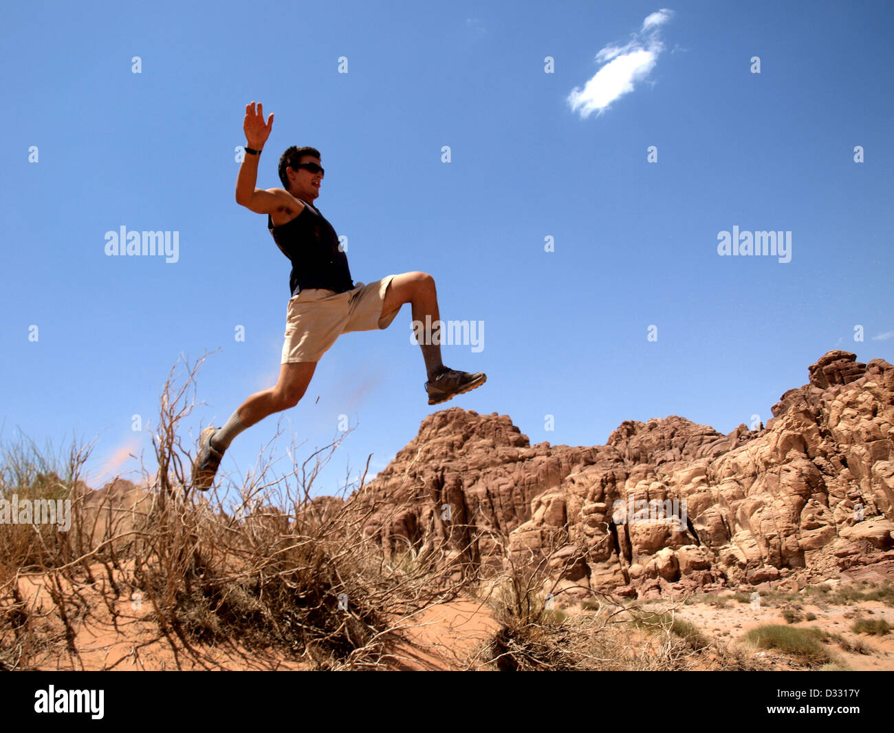 Uomo salta in aria nel deserto a Wadi Rum. Foto Stock