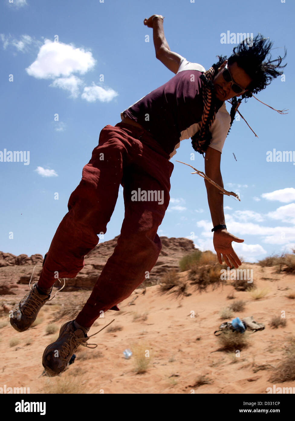 Uomo salta in aria nel deserto a Wadi Rum. Foto Stock