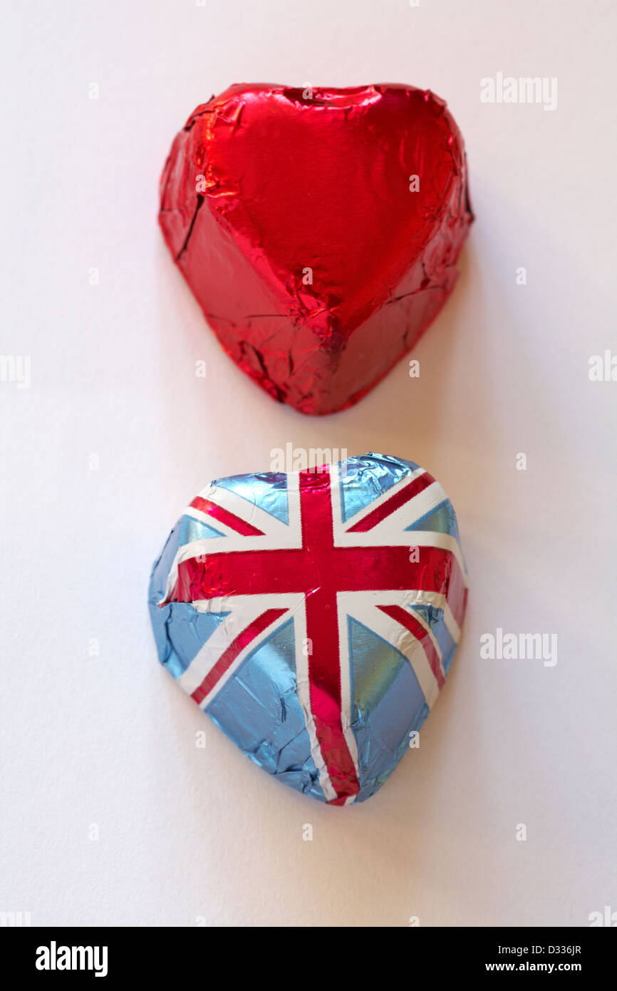 Due a forma di cuore ad cioccolatini, uno in Unione Jack involucro in foglio e uno in lamina di rosso isolato su sfondo bianco Foto Stock