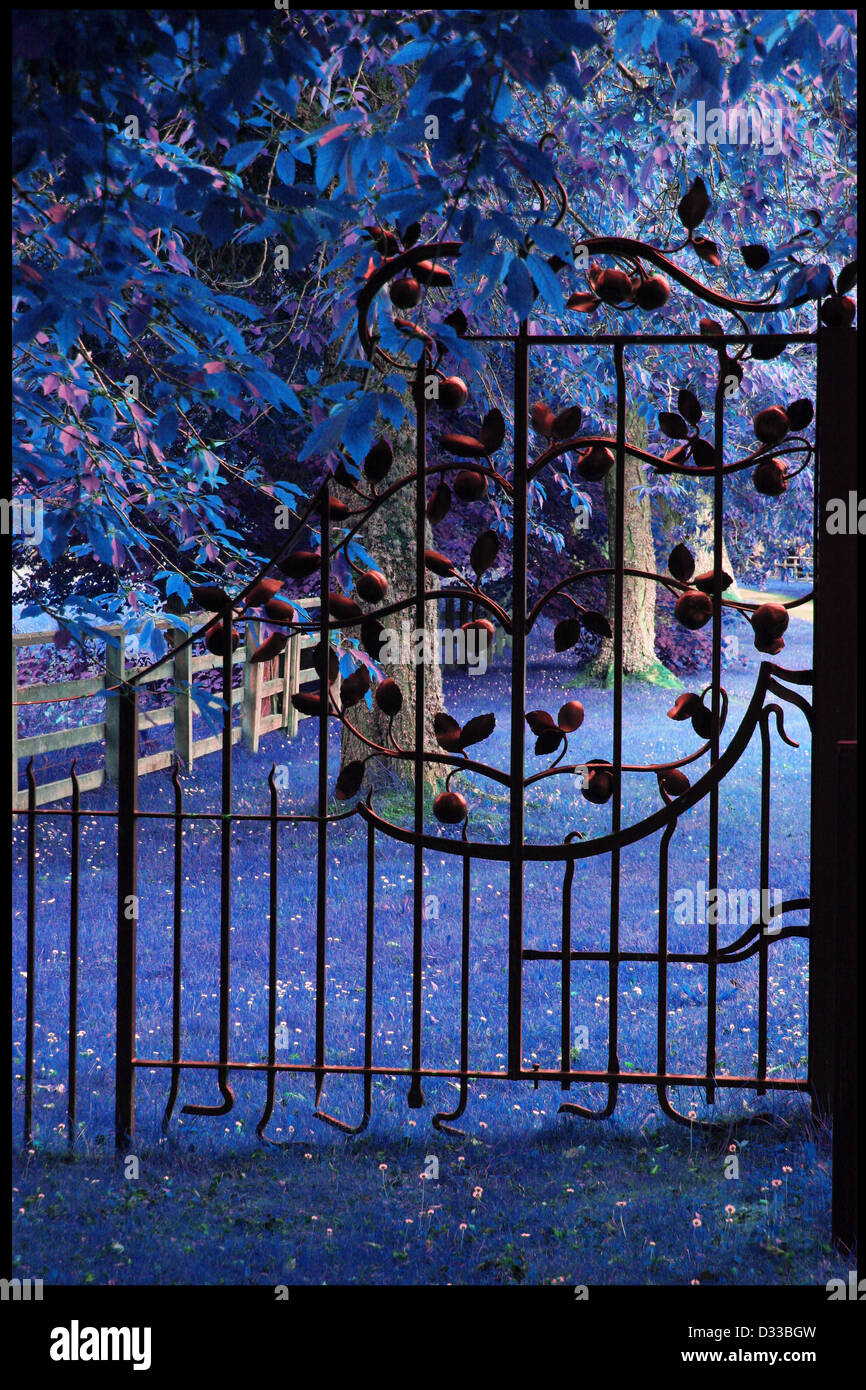Magico giardino dietro alto cancello ornati Foto Stock