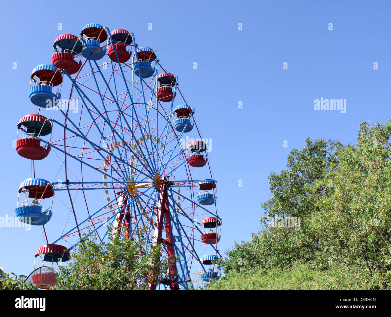 Ruota panoramica Ferris in un parco di divertimenti oltre il cielo blu Foto Stock