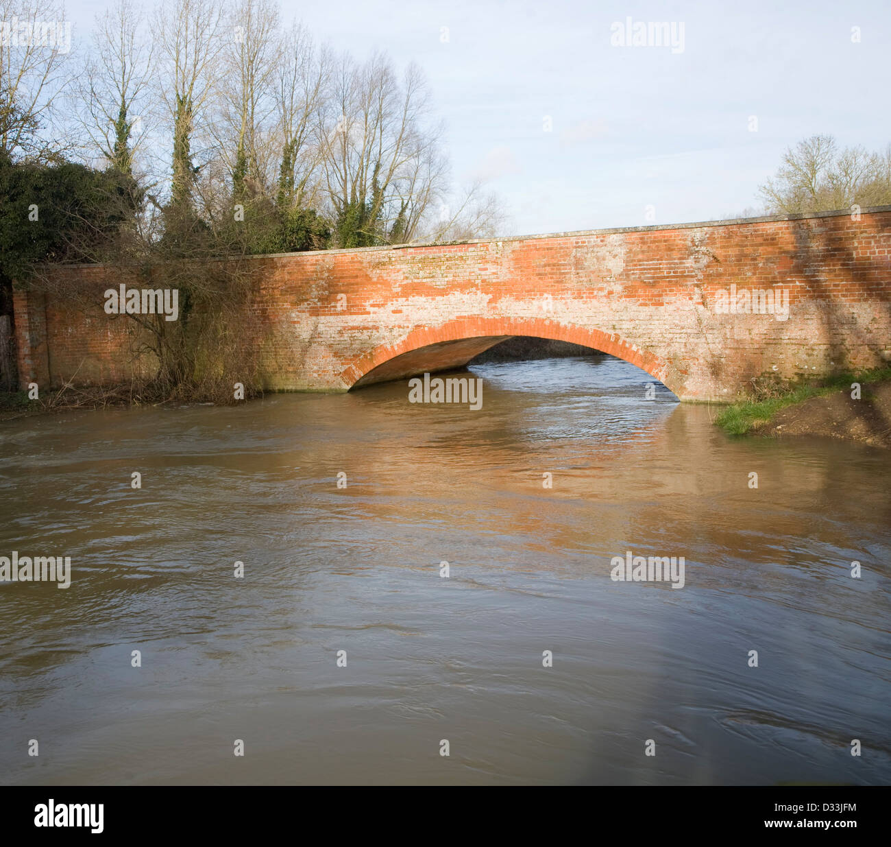 Mattone rosso ponte che attraversa il fiume gonfio Deben Dopo forti piogge, Ufford, Suffolk, Inghilterra Foto Stock